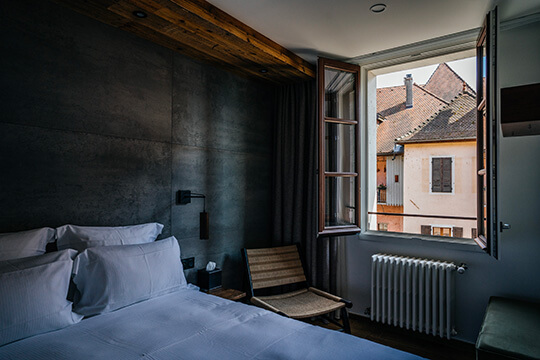A bed by the window in the Auberge du Lyonnais hotel