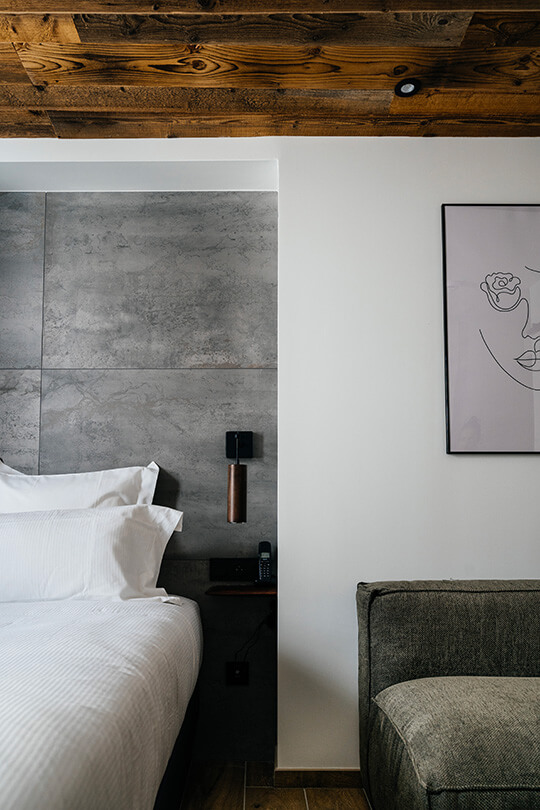 A painting positioned next to a bed at the Auberge du Lyonnais