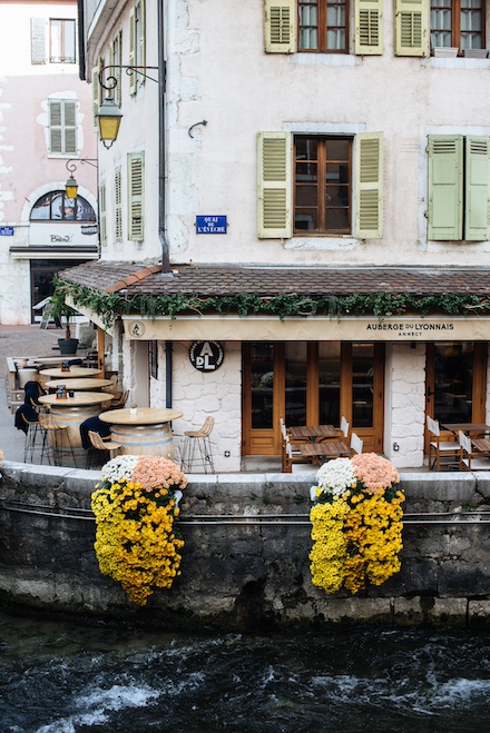 view of the Auberge du Lyonnais in Annecy from the bank of the Thiou river
